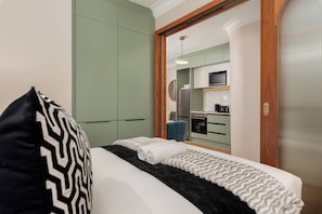 Ein Hotelzimmer mit Bett, Schrank, Küchenzeile und Badezimmer.
