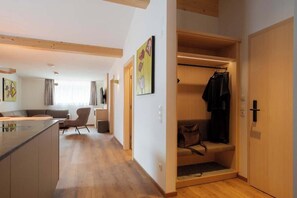 Ein modernes Apartment mit Küche, Essbereich, Wohnzimmer und begehbarem Kleiderschrank.