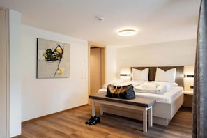 Ein Hotelzimmer mit Bett, Nachttisch und einem Bild an der Wand.