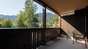 Ein Balkon mit Blick auf eine bewaldete Bergkette.