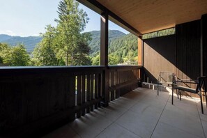 Ein Balkon mit Blick auf eine bewaldete Bergkette.