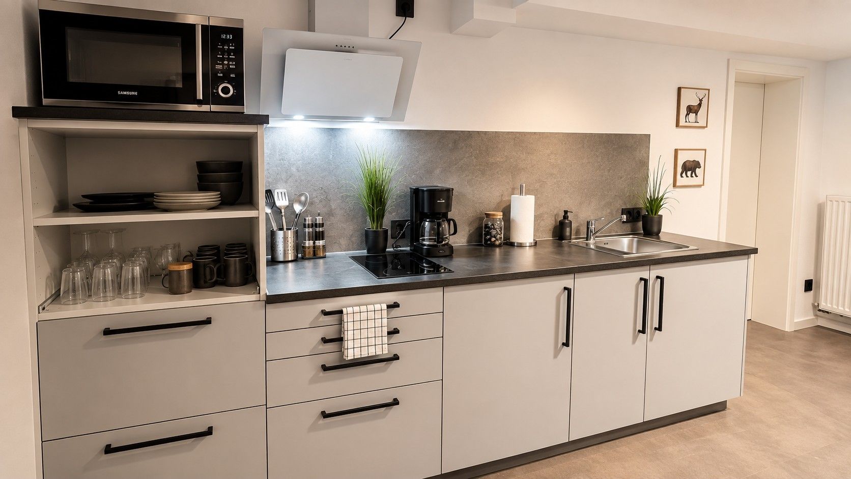 Eine moderne Küche mit Mikrowelle, Kaffeemaschine und Spüle.