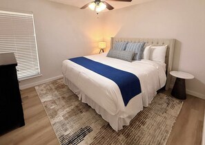 A bedroom with a bed, bedside table, lamp, and a ceiling fan. - Tahoka Flats, Boutique Luxury Near Trinity & Pearl (San Antonio)
