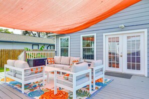 A covered patio area with outdoor furniture and a wooden deck. - 4BR Near Alamodome & Pearl | Sleeps 10 (San Antonio)