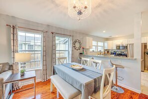 A modern kitchen with white cabinets, stainless steel appliances, and a dining area with a table and chairs. - 4BR Near Alamodome & Pearl | Sleeps 10 (San Antonio)
