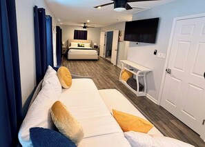 Een hotelkamer met een bed, een aan de muur bevestigde televisie, een bureau en een kledingkast.
