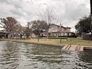 A residential area with a house, a body of water, and a flagpole. - 75' Amazing Lake View   Dock   Pets  Gameroom (Granite Shoals)