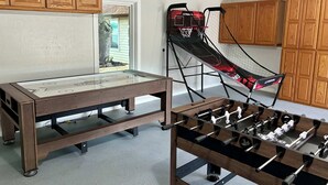 A room with a foosball table, a table tennis table, and a basketball hoop. - 75' Amazing Lake View   Dock   Pets  Gameroom (Granite Shoals)
