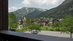 A mountain village with traditional houses, a church, and a clear view of the surrounding hills. - Tafamunt 11 Apartment (Gaschurn)