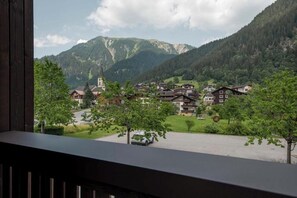 A mountain village with traditional houses, a church, and a clear view of the surrounding hills. - Tafamunt 11 Apartment (Gaschurn)
