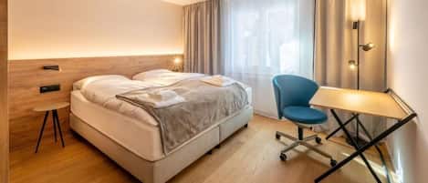 Ein Hotelzimmer mit Bett, Schreibtisch und Stuhl.