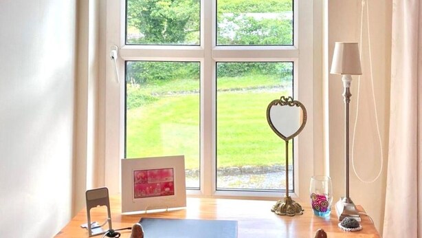 A wooden desk with a chair, a lamp, and a heart-shaped mirror. - Oyster Cove Kilkerrin stunning views (Kilkerrin)