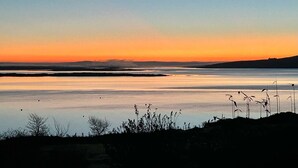 A calm body of water reflecting the sky during sunset. - Oyster Cove Kilkerrin stunning views (Kilkerrin)