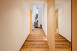 Ein Flur mit Holzboden, der zum Küchenbereich führt.