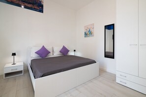 Ein Schlafzimmer mit Bett, Nachttisch, Kleiderschrank und einem Bild an der Wand.