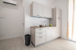 A modern kitchen with a built-in stove, a sink, and a window with curtains. - Lovely 22 sqm studio apartment, for two guests, located on the second floor of a renovated historic building (no elevator). The property enjoys a strategic location just steps away from the Policlinico hospital, the Ballarò district, and the city center (Palermo)