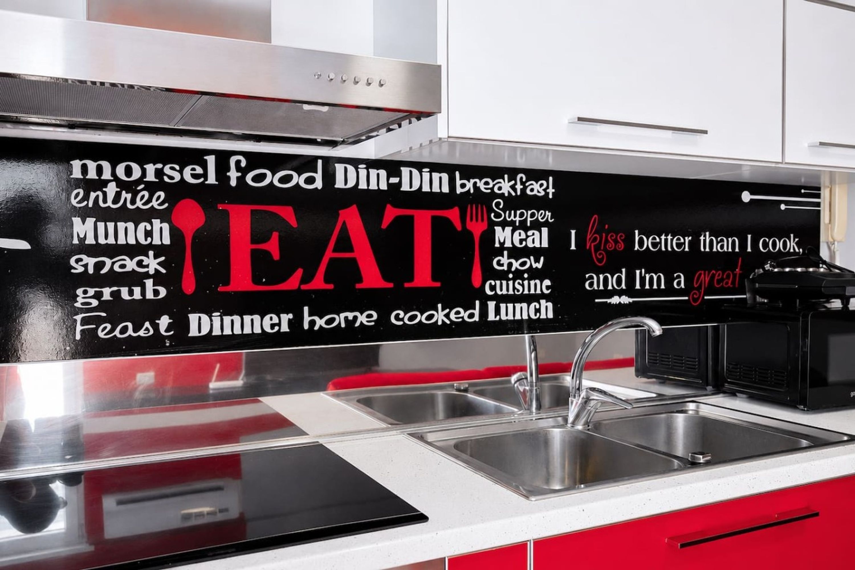 Une cuisine avec un tableau noir sur lequel sont écrits différents mots et expressions liés à l’alimentation.