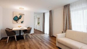 Una sala moderna con un sofá, una mesa de comedor con sillas y un cuadro en la pared.