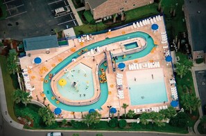Vista aérea de um resort com várias piscinas, espreguiçadeiras e área de parque aquático.