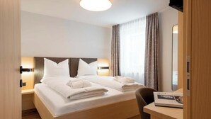 A hotel room with a bed, bedside tables, a desk, and a television. - Versail D1 Apartment (Gaschurn)