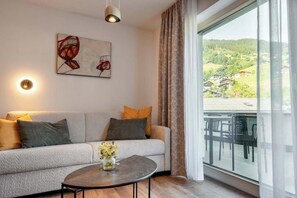 Ein modernes Wohnzimmer mit einer Couch, einem runden Couchtisch und einem Gemälde an der Wand.
