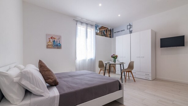 Ein modernes Schlafzimmer mit Bett, Schreibtisch und Kleiderschrank.