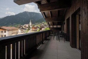 A balcony with a view of a village and mountains. - Apartment Zamangspitze 32 (Gaschurn)