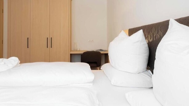 A hotel room with a bed, a desk, and a wardrobe. - Apartment Zamangspitze 32 (Gaschurn)