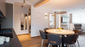 A modern interior with a dining area, built-in seating, and a television. - Apartment Zamangspitze 32 (Gaschurn)