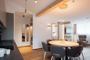 A modern interior with a dining area, built-in seating, and a television. - Apartment Zamangspitze 32 (Gaschurn)