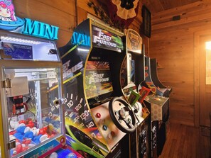 A row of arcade machines in a wooden room. - Smoky Mtn Views  Hot Tub  Sauna Game Room (Sevierville)