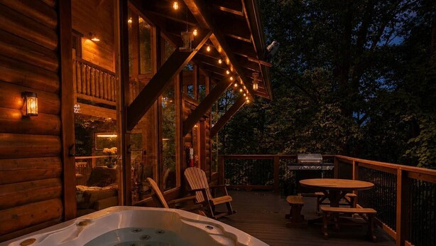 A wooden deck with a hot tub, outdoor seating, and a barbecue grill. - Smoky Mtn Views  Hot Tub  Sauna Game Room (Sevierville)