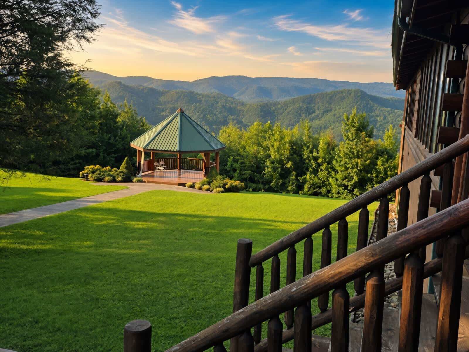 Um gazebo com telhado verde, rodeado por um jardim bem cuidado, e uma cordilheira ao fundo.
