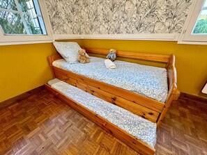 A wooden bench with a patterned cushion, a teddy bear, and a blanket. - Logement 100m² - La Villa' Tyno - 9 couchages (La Teste-de-Buch)