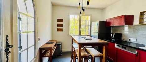 A kitchen with wooden benches, a red cabinet, and a window with a view.