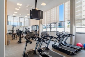 A gym with treadmills, exercise bikes, and weight machines. - Comfort in Condo. w/ Pool and Balcony Lss1318 (São Paulo)