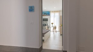 Un pasillo que conduce a un comedor con una cocina al fondo.
