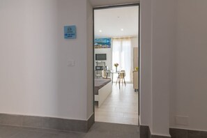 Ein Flur, der in einen Essbereich führt, mit einer Küche im Hintergrund.