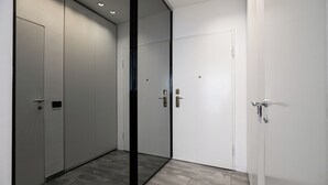 En hall med en modern hiss och en dörr med ett handtag.