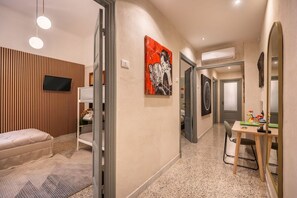 A hotel room with a bed, a desk, a chair, a television, and artwork on the walls. - [LaViaDelleSpezie] next station+ 5Terre + A/C (La Spezia)