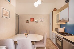 A compact kitchen with a dining area, a microwave, a stove, and a small refrigerator. - [LaViaDelleSpezie] next station+ 5Terre + A/C (La Spezia)