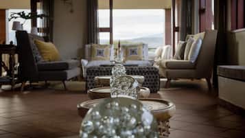 Amplia sala de estar con un conjunto de sofás, una mesa de centro y cuencos de vidrio decorativos.
