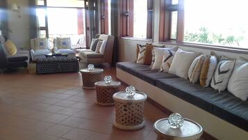 A spacious living area with a sofa set, a coffee table, and decorative stools.