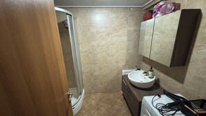 A bathroom with a shower, a sink, a mirror, and a washing machine. - Beautiful 1-bedroom apartment in tranquil İstanbul neighborhood (İstanbul)