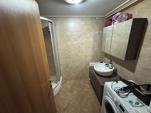 A bathroom with a shower, a sink, a mirror, and a washing machine. - Beautiful 1-bedroom apartment in tranquil İstanbul neighborhood (İstanbul)