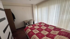 A bedroom with a bed, a desk, a chair, and a wardrobe. - Beautiful 1-bedroom apartment in tranquil İstanbul neighborhood (İstanbul)