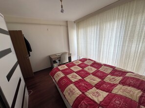 A bedroom with a bed, a desk, a chair, and a wardrobe. - Beautiful 1-bedroom apartment in tranquil İstanbul neighborhood (İstanbul)