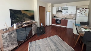 A compact living space with a TV, a dining area, and a kitchenette. - Beautiful 1-bedroom apartment in tranquil İstanbul neighborhood (İstanbul)