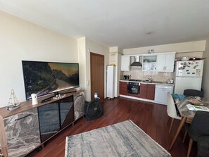 A compact living space with a TV, a dining area, and a kitchenette. - Beautiful 1-bedroom apartment in tranquil İstanbul neighborhood (İstanbul)