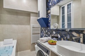 A modern bathroom with a white sink, a mirror, and a towel rack. - Lavie Maison - Spa Bath & AC, Heart of Saint-Merri (Paris)